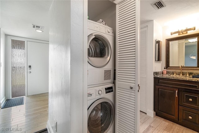 washroom featuring sink and stacked washer / dryer