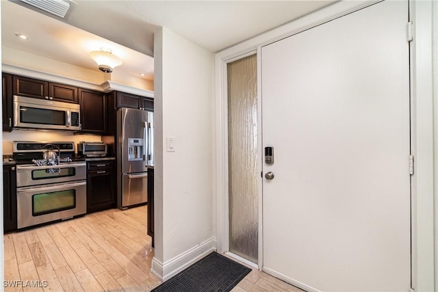 kitchen with light hardwood / wood-style flooring, stainless steel appliances, and dark brown cabinetry