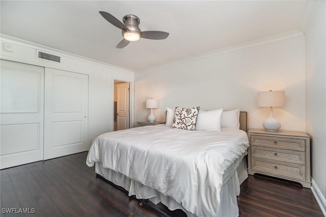 bedroom featuring ceiling fan, dark hardwood / wood-style floors, a closet, and ornamental molding