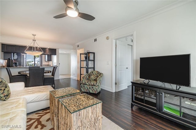 living room with ceiling fan, dark hardwood / wood-style floors, and crown molding