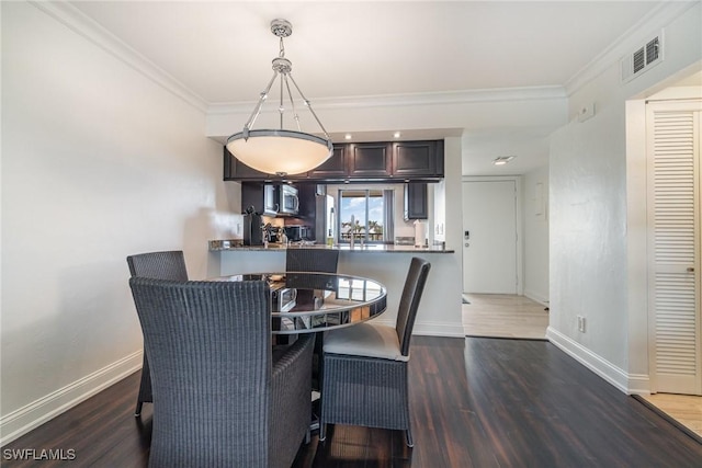 dining room featuring dark wood-type flooring and ornamental molding