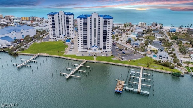 aerial view at dusk featuring a water view