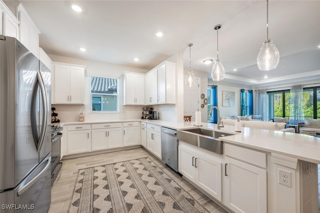 kitchen with stainless steel appliances, white cabinets, hanging light fixtures, and sink