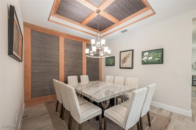 dining area with wooden ceiling, ornamental molding, an inviting chandelier, and coffered ceiling