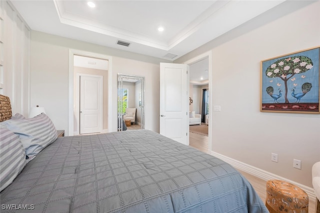 bedroom with ornamental molding and a raised ceiling