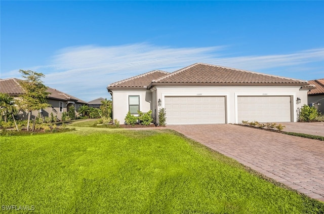 mediterranean / spanish home with a front lawn and a garage