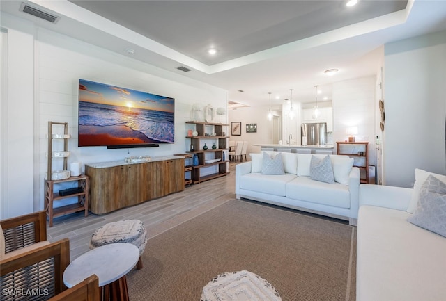 living room featuring sink and a raised ceiling