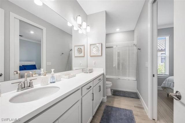 full bathroom with toilet, vanity, and shower / bath combination with glass door