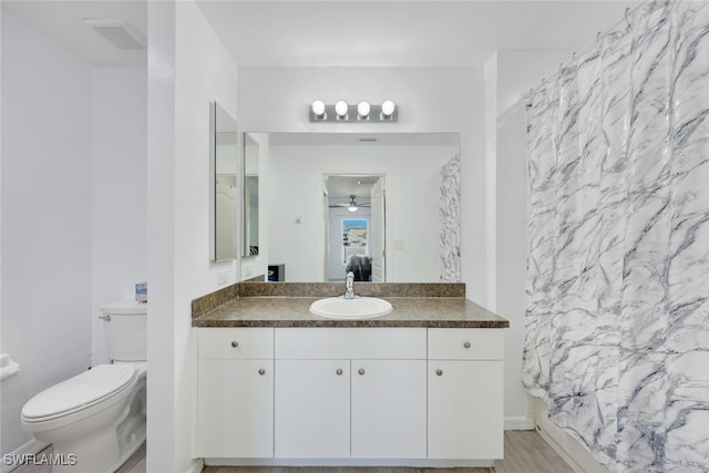 full bathroom with shower / bath combo with shower curtain, toilet, and vanity