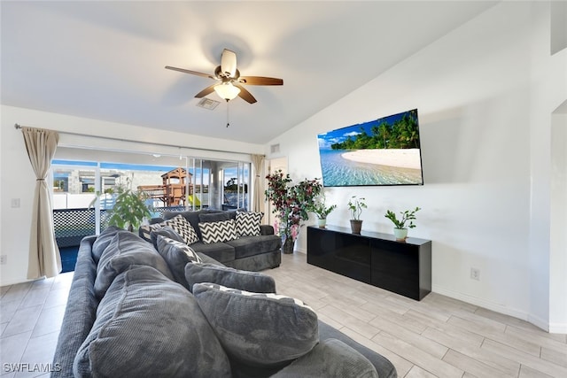 living room with vaulted ceiling, ceiling fan, and light wood-type flooring