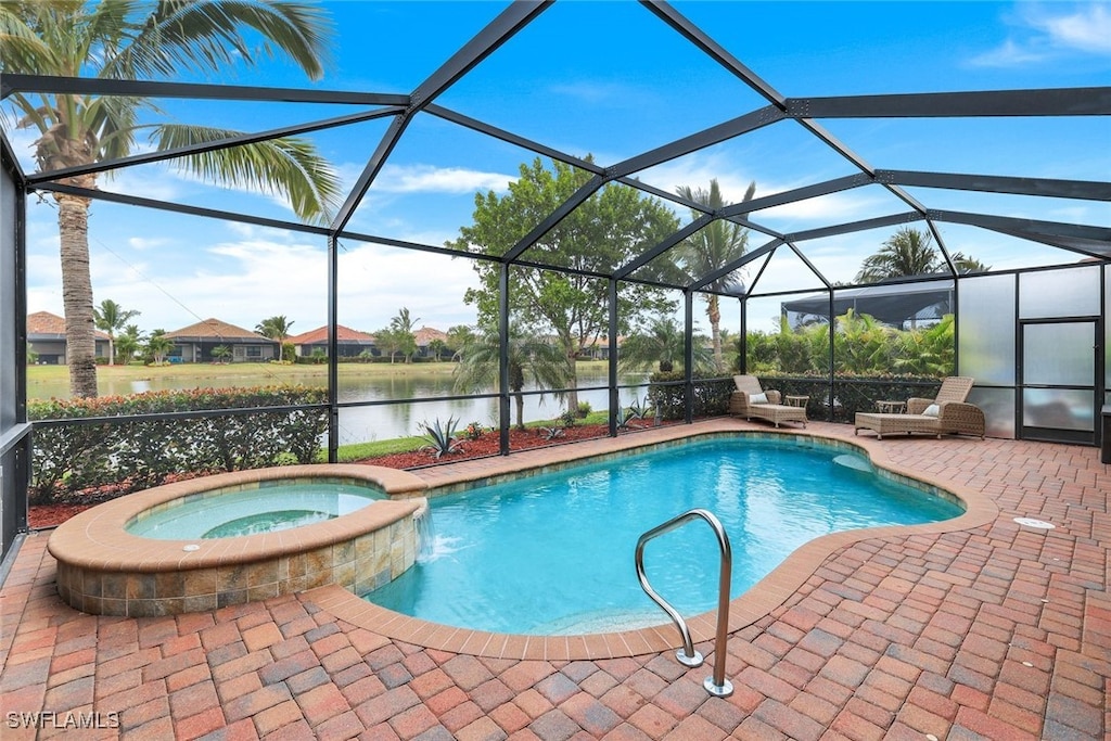 view of pool featuring glass enclosure, a water view, an in ground hot tub, and a patio