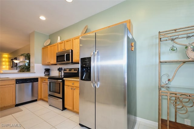 kitchen with backsplash, light tile patterned flooring, and stainless steel appliances