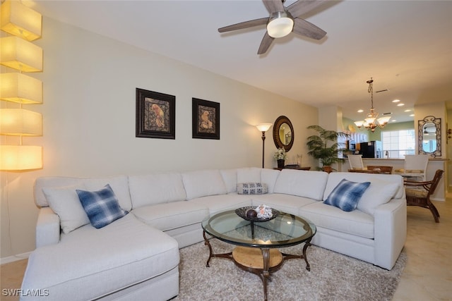 tiled living room with ceiling fan with notable chandelier