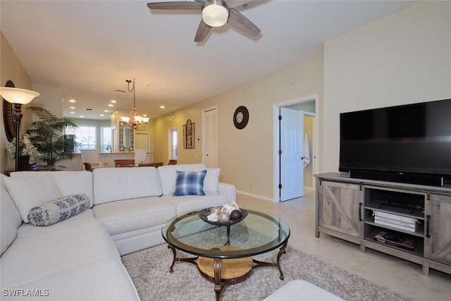 tiled living room with ceiling fan with notable chandelier