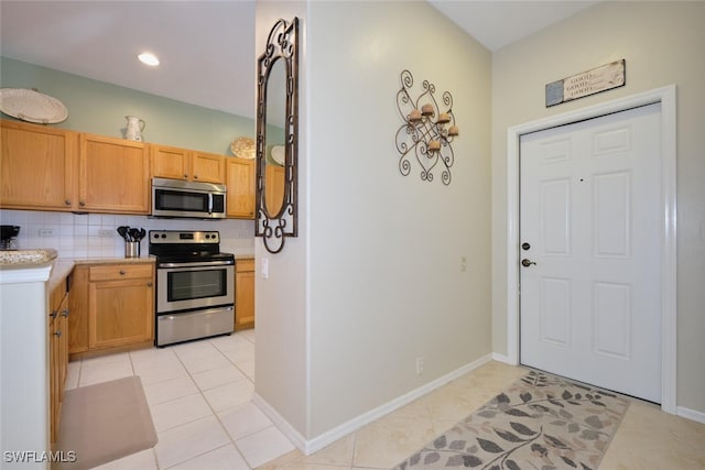 kitchen featuring light tile patterned floors, backsplash, and stainless steel appliances