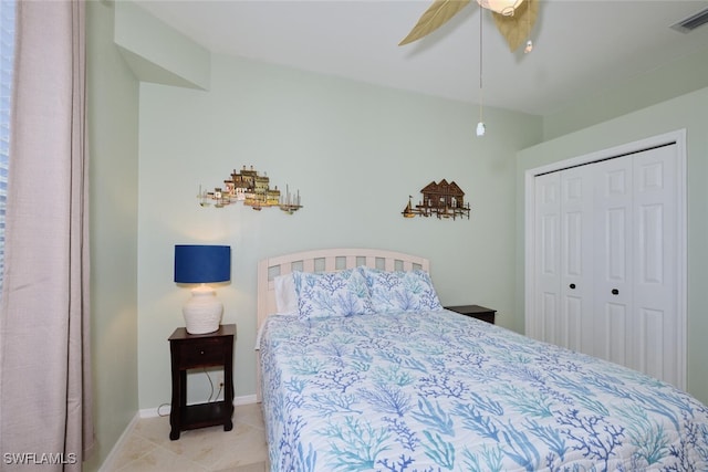 bedroom with ceiling fan, light tile patterned floors, and a closet