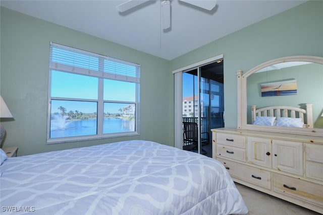 bedroom featuring ceiling fan and a water view