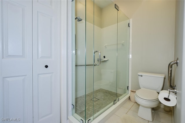 bathroom with toilet, tile patterned flooring, and walk in shower