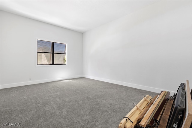 unfurnished room featuring dark colored carpet