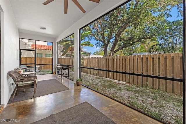 unfurnished sunroom featuring ceiling fan