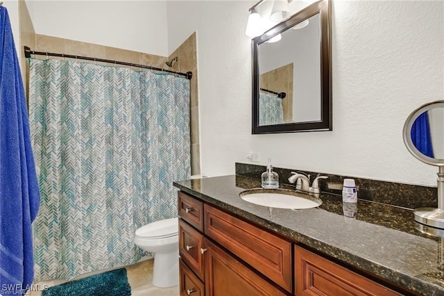 bathroom featuring toilet, a shower with shower curtain, and vanity