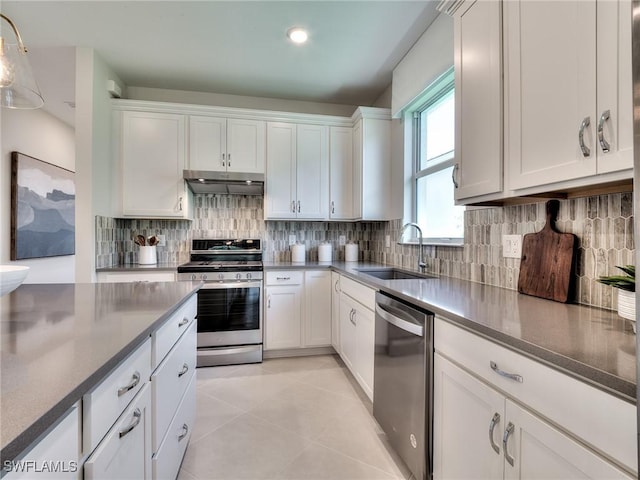 kitchen featuring light tile patterned floors, sink, white cabinets, and stainless steel appliances