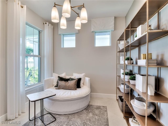 living area featuring light tile patterned floors, a notable chandelier, and a wealth of natural light