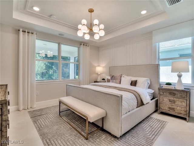 bedroom with a notable chandelier, light tile patterned flooring, and a tray ceiling