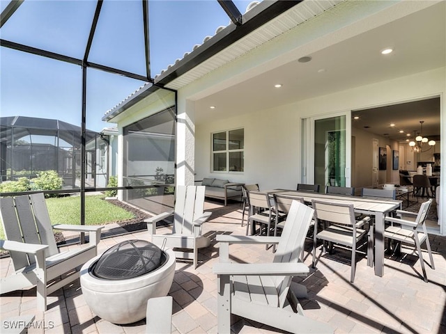 view of patio featuring an outdoor living space with a fire pit and glass enclosure