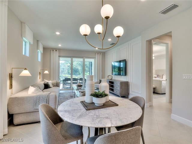 tiled dining space featuring an inviting chandelier and washer / dryer