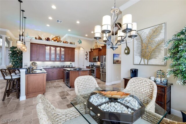 dining space featuring sink, ornamental molding, a notable chandelier, and wine cooler