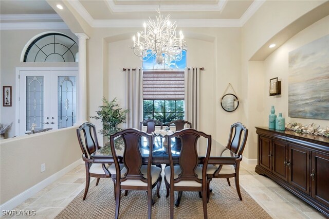 dining area featuring decorative columns, a chandelier, a tray ceiling, and ornamental molding