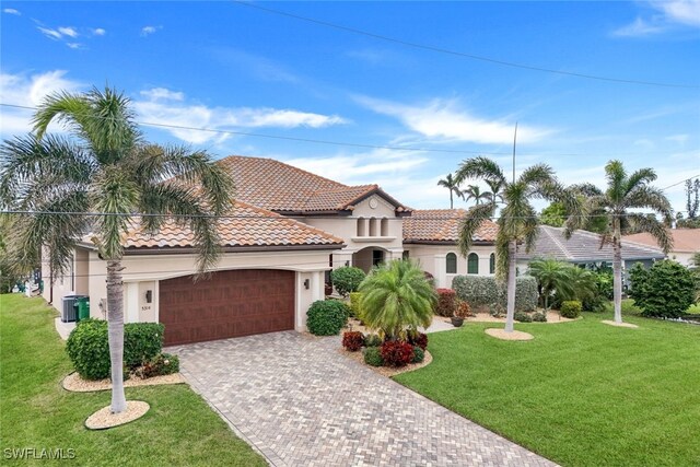 mediterranean / spanish-style house featuring a front yard and a garage