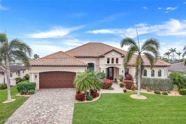 mediterranean / spanish-style house featuring a garage and a front lawn