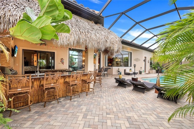 view of patio with a bar and glass enclosure