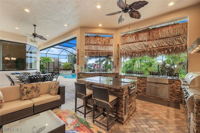 view of patio / terrace featuring an outdoor living space, ceiling fan, an outdoor wet bar, and area for grilling