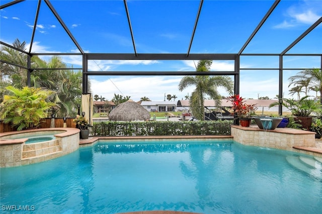 view of pool with an in ground hot tub and glass enclosure