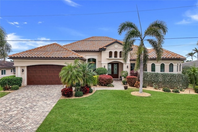 mediterranean / spanish-style home featuring a front yard and a garage