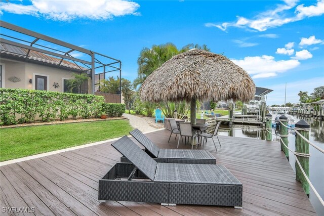 wooden terrace featuring a lanai, a lawn, and a water view