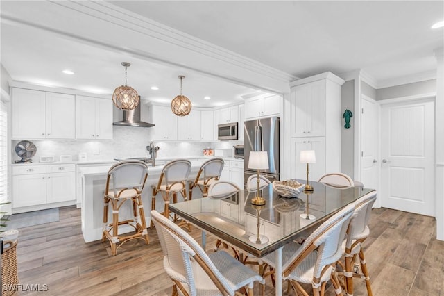 dining room with hardwood / wood-style flooring and crown molding