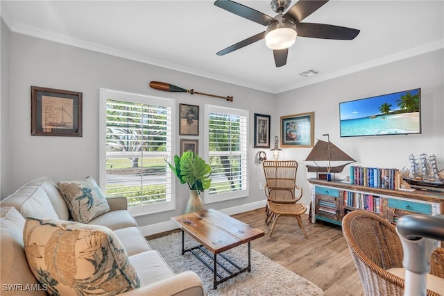 living room featuring ornamental molding, a healthy amount of sunlight, and light hardwood / wood-style flooring