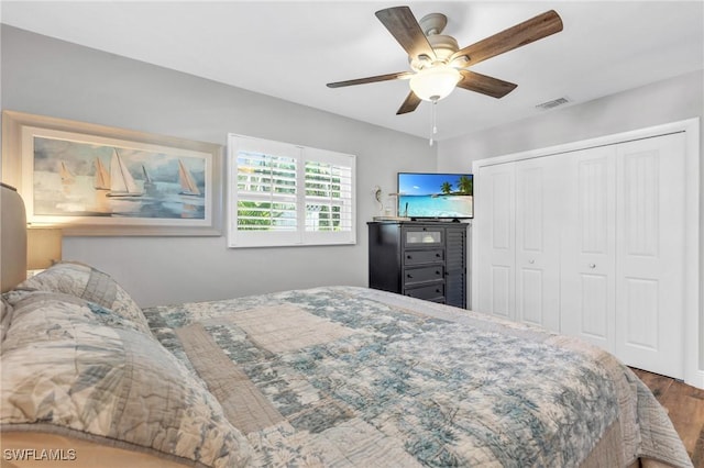 bedroom with ceiling fan, a closet, and hardwood / wood-style flooring