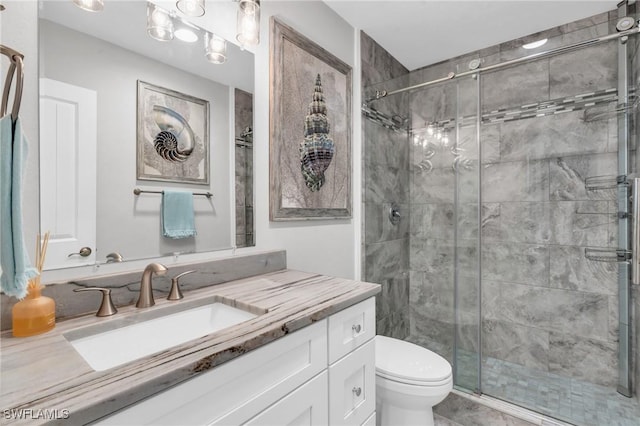 bathroom featuring an enclosed shower, vanity, and toilet