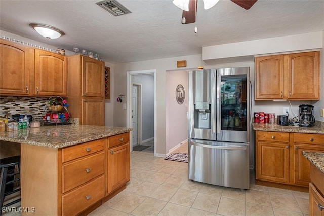 kitchen with stainless steel fridge with ice dispenser, light tile patterned flooring, beverage cooler, and stone countertops