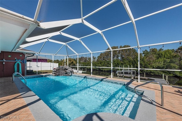 view of swimming pool with a lanai, pool water feature, and a patio