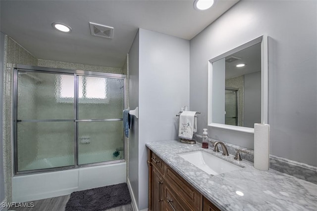 bathroom featuring vanity, shower / bath combination with glass door, and hardwood / wood-style floors