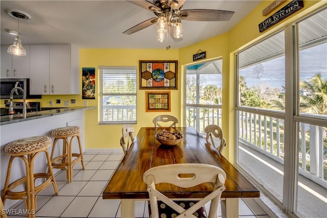 tiled dining space featuring ceiling fan