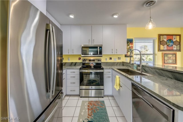 kitchen with light tile patterned floors, appliances with stainless steel finishes, white cabinets, and sink