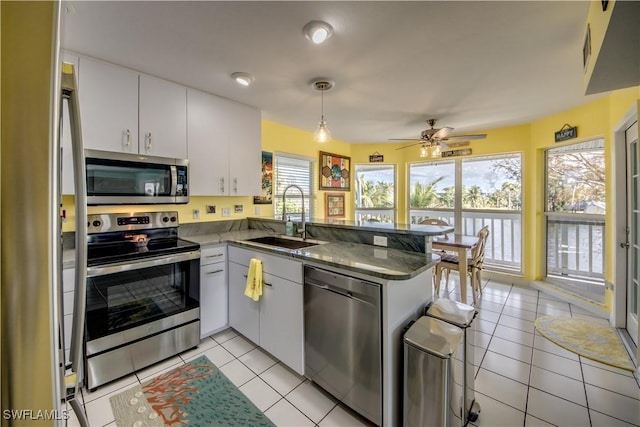 kitchen featuring appliances with stainless steel finishes, white cabinets, kitchen peninsula, and sink