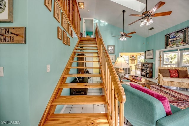 stairway with high vaulted ceiling, tile patterned floors, and ceiling fan